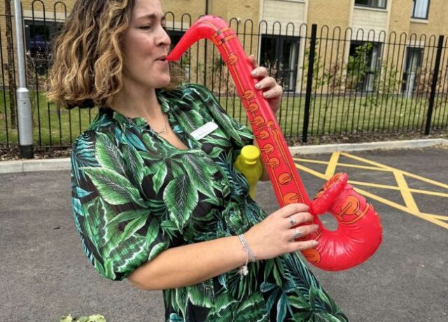 Team member at Oadby Manor Care Home, Oadby, Leicestershire playing inflatable saxophone.